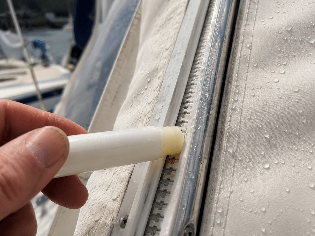 Cerniera di un tendalino nautico pulita e lubrificata con stick di cera contro la salsedine
