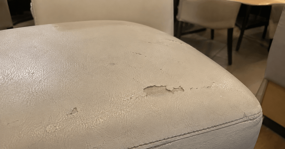 Sedute e divanetti imbottiti di una sala ristorante in tessuto contract resistente, luce calda
