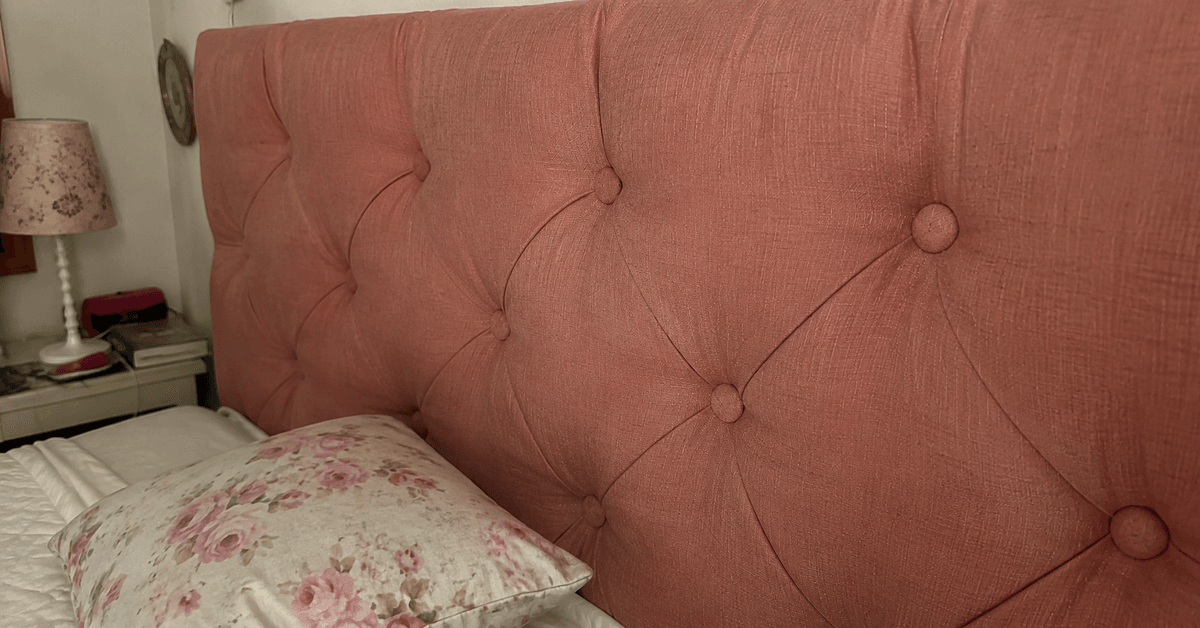 Camera da letto con testiera imbottita su misura in tessuto naturale con lavorazione capitonné