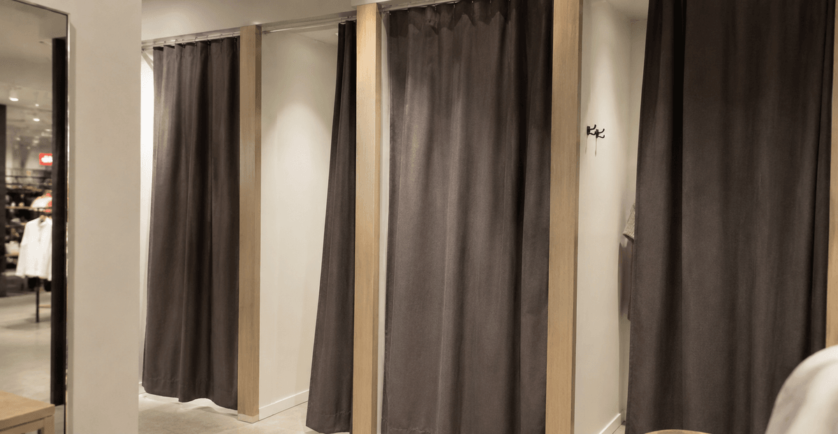 Camerino di prova di un negozio con tenda in tessuto pesante e binario a soffitto