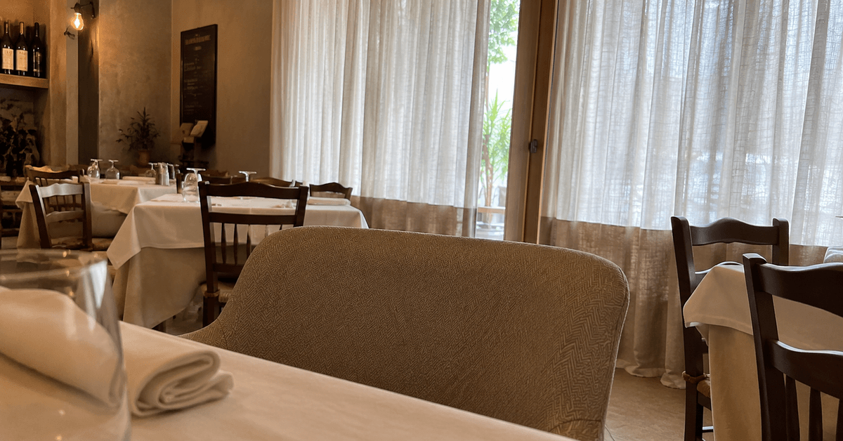 Sala di ristorante elegante con tendaggi e sedute in tessuto ignifugo Classe 1