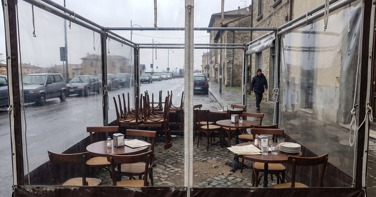 Dehor di un bar chiuso per l'inverno con teli laterali in cristal trasparente e fascia bassa in tessuto tecnico