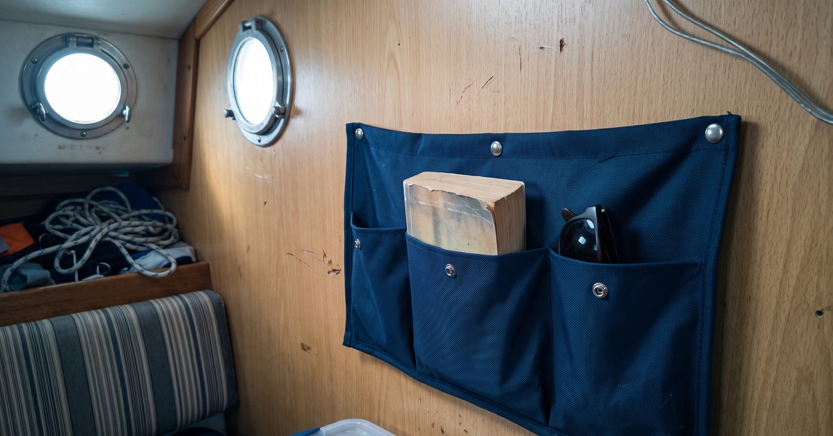 Tasche portaoggetti in tessuto tecnico cucite su misura e fissate con bottoni a pressione alla paratia della cabina di una barca